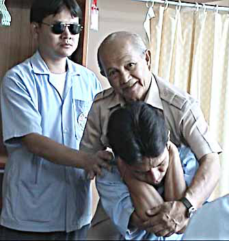 Ajahn Pisit
		        instructing the blind in Thai Massage